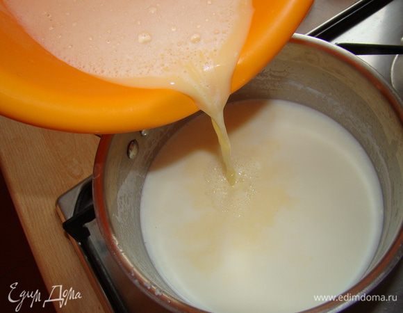 Вливаем порцию горячего молока в желтки, размешиваем и возвращаем опять на огонь