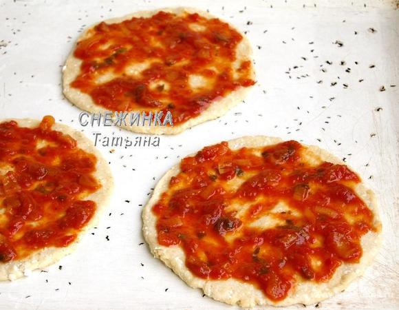 Тесто делим на три равные части. Раскатываем каждую в достаточно тонкий круг, около 5 мм высотой. Кладём на смазанный маслом противень. Смазываем томатным соусом. Если у Вас томатная паста, то приправьте сверху травами.