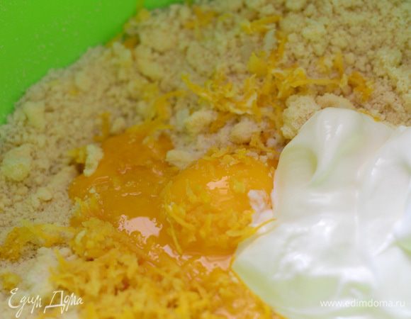 К крошке добавить желтки, ванильный сахар, сметану, цедру лимона и быстро замесить тесто, чтобы не приставало к рукам.