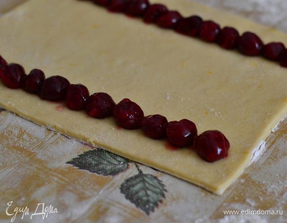 Ближе к краю выложить вишню в ряд плотно друг к другу.