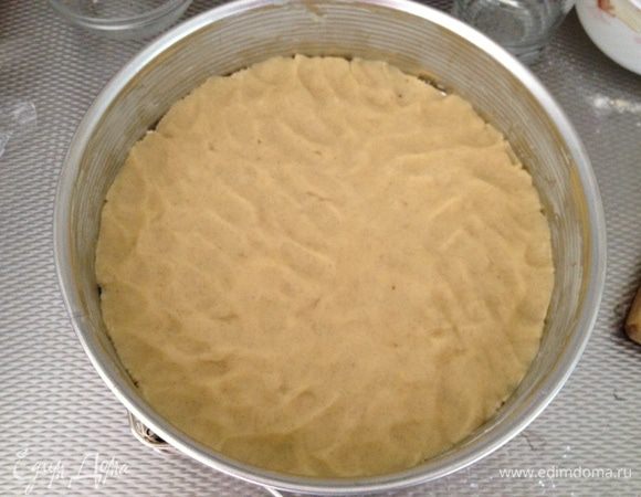 Достаем тесто из холодильника. Форму смазываем сливочным маслом (у меня размер 26) и разравниваем пальцами тесто по форме.