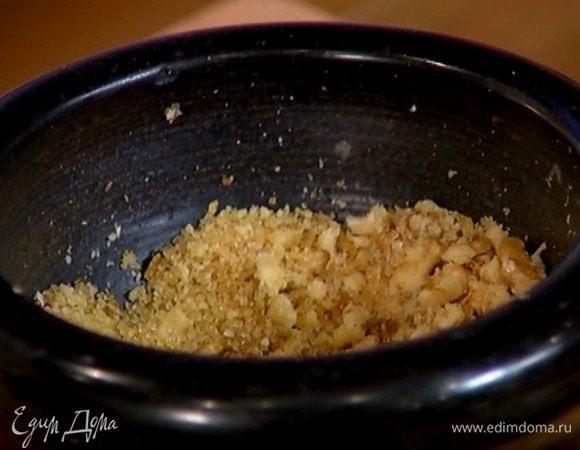 Оставшиеся грецкие орехи соединить в ступке с коричневым сахаром, гвоздикой и мускатным орехом и измельчить все в крошку.