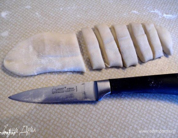 Приготовить ленивые вареники: Пельменное тесто разделить на 4 равных части. Из каждой части скатать небольшую колбаску (длина 10 см). Раскатать из них "язычки" толщиной 0.5 см  и порезать на брусочки шириной около 1 сантиметра. Разделочную доску присыпать мукой и сложить на неё брусочки из теста - будущие ленивые вареники..