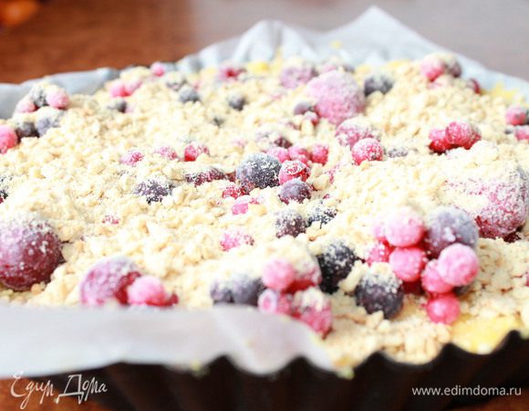 Перед выпечкой достать тесто, размять руками, и раскатать в паст. Выложить в форму, распределить ягодный коктейль и посыпать, измельчённым в блендере, печеньем. Отправить в разогретую духовку до 220-240 С и выпекать до золотистого цвета.