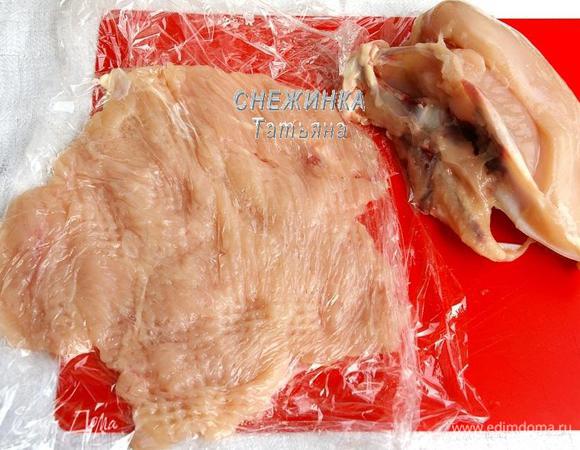 Куриную грудку моем, делая надрезы в толстых местах как бы разворачиваем её. Затем помещаем между пластами пищевой плёнки и хорошо отбиваем. Кусок должен сохранится обязательно цельным.