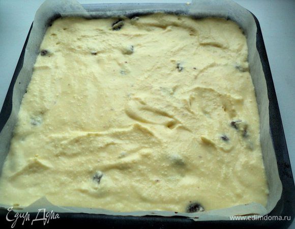 Форму застелить бумагой для выпечки, положить подпеченный светлый корж из теста 1. Сверху распределить творожную массу.