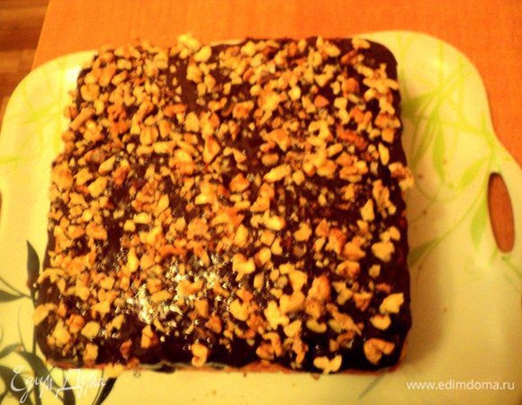 Сварить шоколадную помадку: в кружке смешать какао, сахар, молоко. Поставить на небольшой огонь и, постоянно помешивая, довести до кипения. Снять с огня, добавить сливочное масло, размешать до его растворения. Залить пляцок помадкой и посыпать дробленными орехами. Поставить в холодильник на 3 часа для застывания.