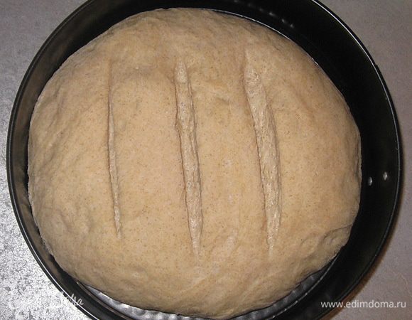 Духовку разогреть до 230 с. На хлеб нанести надрезы. Поставить форму в разогретую духовку, выпекать 10 минут. Затем убавить до 200 с и выпекать 20-30 минут.