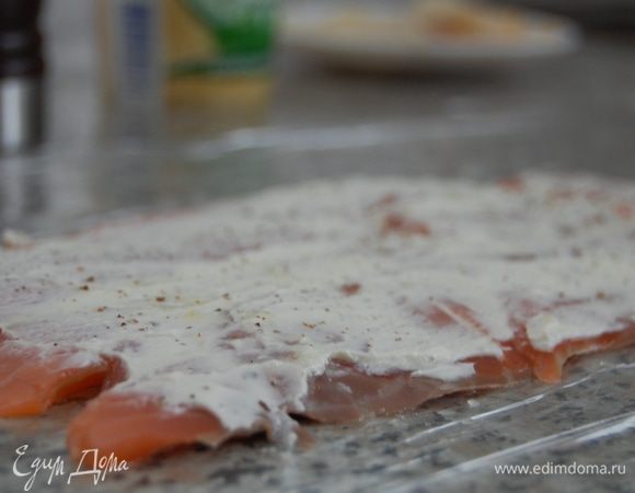  На столе в два слоя сложить пищевую пленку, поверх плотно уложить семгу в виде прямоугольника. Сбрызнуть соком лимона, приправить перцем и смазать  творожным сыром (25 г).