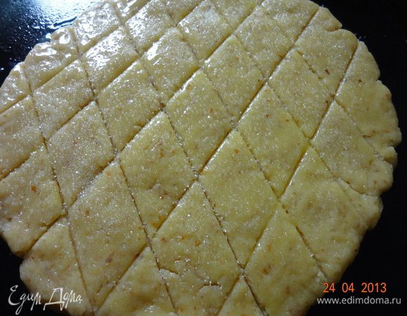 Затем раскатать тесто в круглую лепешку d 15-20 см (можно на бумаге для выпечке, чтобы удобно было переносить), начертить решетку тупой стороной ножа, смазать желтком и посыпать сахаром, переложить на противень. Отправить в духовку, нагретую до 190 С на 20 минут.