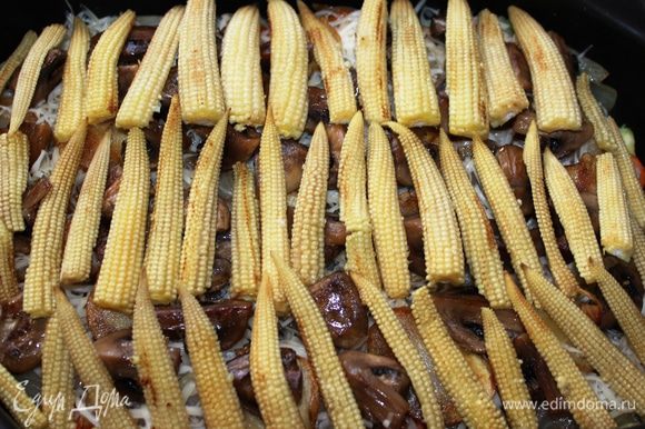 Следующий слой - кукуруза. Ее необходимо поджарить в масле, нарезать пополам вдоль и разложить поверх грибов