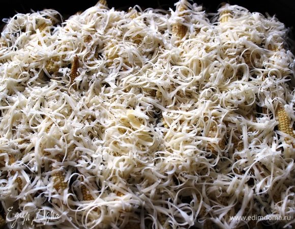 Кукурузу посолить, поперчить и присыпать тертым сыром