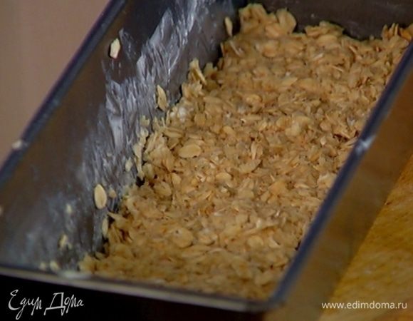 Небольшую продолговатую форму для выпечки смазать оставшимся сливочным маслом, выложить половину теста и слегка утрамбовать его.