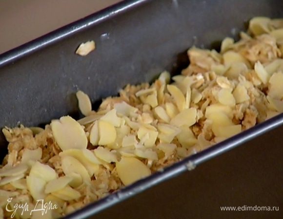 На финики раскрошить руками оставшееся тесто, посыпать оставшимися миндальными лепестками и сахаром.