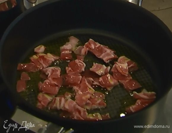 В глубокой тяжелой сковороде разогреть оливковое масло и обжарить бекон до золотистого цвета.