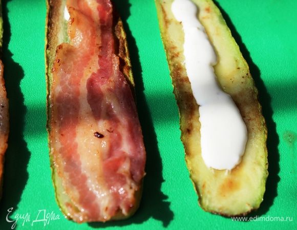 Начинаем собирать рульки...я делала двумя способами - сначала кабачок, затем бекон...и наоборот - сначала бекон, а затем кабачок. Оба варианта хороши))) На доску разложить пластинки кабачков (бекона), а сверху нанести немного соуса. Поверх соуса разместить пластинки бекона (кабачков)