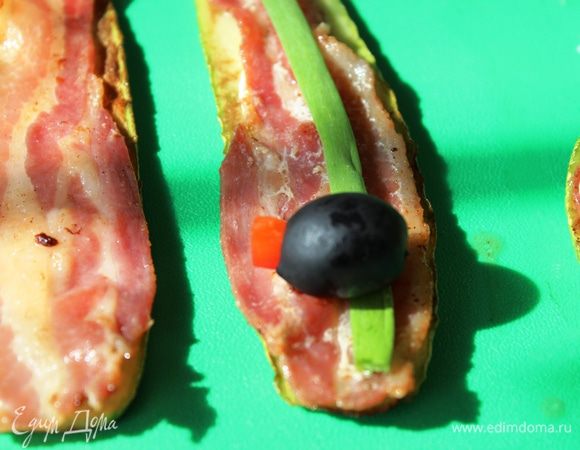 По центру разместить половину перышка зеленого лука, на него с одного края положить сюрприз: это может быть оливка без косточки, в центр которой необходимо поместить кусочек яркого болгарского перца...