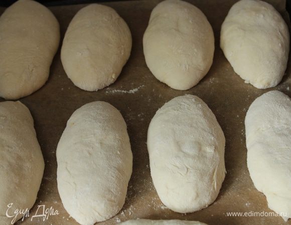 Подготовленные пирожки выкладываем на противень, выстеленный бумагой для выпечки и оставляем на 30 минут на расстойку.