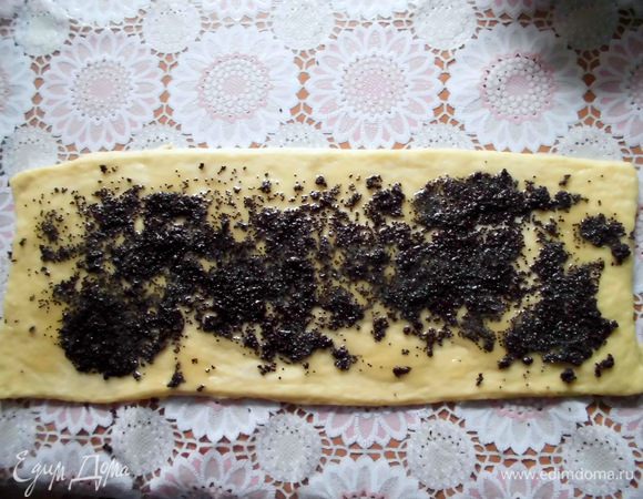 Из части оставшегося теста раскатать тонкую, не очень широкую полоску. Смочить ее водой и равномерно нанести слоем мёда и мака (мёд я растопила, а мак предварительно залила горячей водой). Завернуть полоску в плотный рулет. Разрезать на тонкие ломтики.