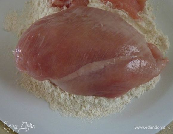 Насыпать муку на тарелку. Обвалять курицу в муке, стряхивая излишки. 
