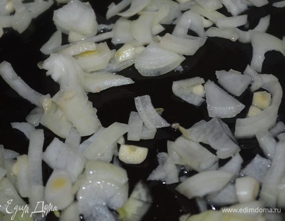 Лук и чеснок мелко нарубить и выложить на разогретое масло