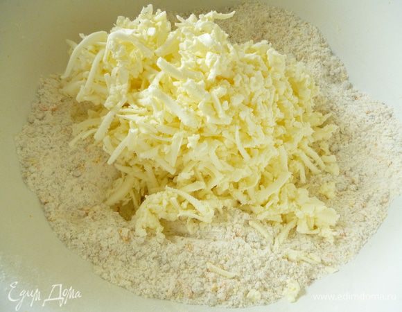 Холодное сливочное масло натереть на крупной терке и быстро соединить с  мучной смесью до состояния крошки.