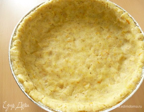 Духовку нагреть до 170 градусов. Дно формы для выпечки (у меня из фольги) смазать маргарином и подпылить манкой. Достать тесто из холодильника, отделить 1/3 часть для оформления решетки, а остальное руками распределяем  в форме для выпечки, формуем бортик.. Тесто очень податливое в работе, можно обойтись без скалки. Ставим форму с тестом в духовку и выпекаем 10 минут, тесто должно немножко схватиться. Достаем из духовки.