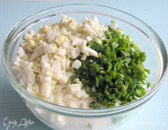В первую часть добавьте мелко нарубленные яйца и мелко нарезанный лук. Перемешайте.