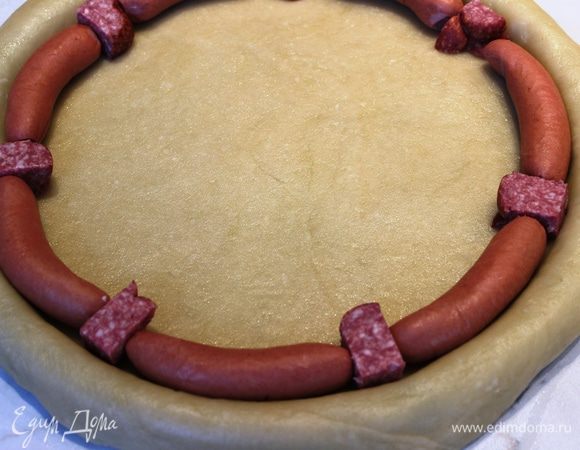 По окружности разложить сосиски (признаюсь, у меня было всего 7 сосисок, поэтому промежутки между ними я заполнила копченой колбасой)