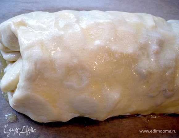 Сворачиваем при помощи полотенца в плотный рулет и перекладываем его осторожно с полотенца швом вниз на застеленный пекарской бумагой противень. Смазываем сверху растопленным сливочным маслом. Ставим в духовку примерно на 35 минут.