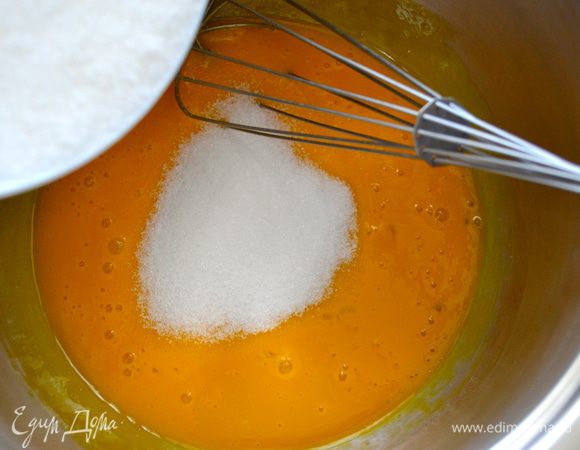 Всыпьте сахар и продолжайте перемешивать с желтками до полного растворения сахара.