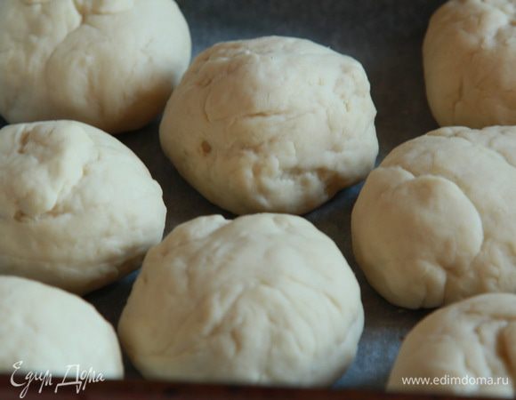 Противень застилаем пергаментом и выкладываем пампушки в противень. Ставим на расстойку пока духовка прогревается до 200 градусов. Отправляем пампушки в духовку.
