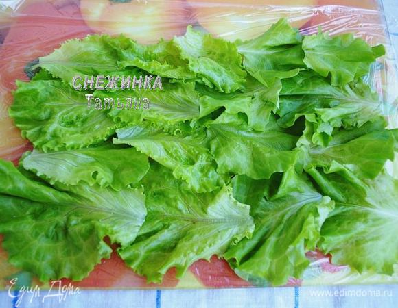 На рабочую поверхность расстилаем пищевую плёнку. На неё внахлёст кладём листья салата.