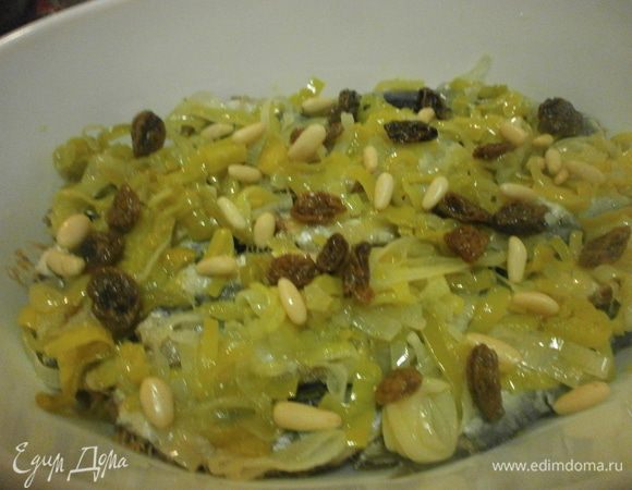 Выложив последний слой сардин, закрываем слоем лука. Посыпаем оставшимся изюмом и орехами. 