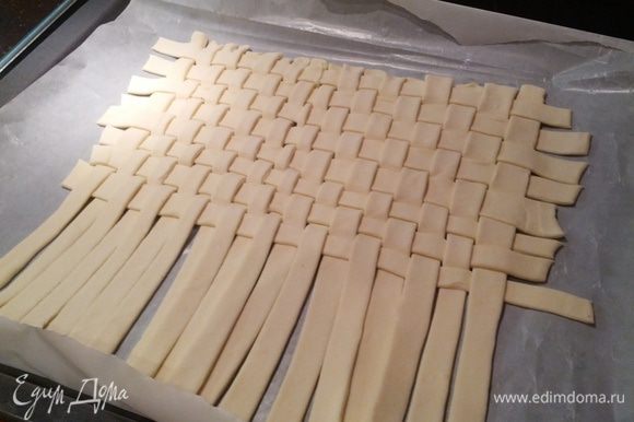 Берем слоеное тесто, раскатываем немного и разрезаем на полосочки по 1 см, затем из полосочек плетем "коврик"