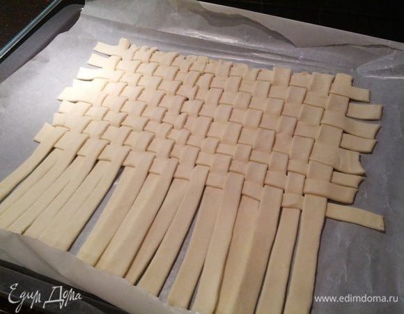 Берем слоеное тесто, раскатываем немного и разрезаем на полосочки по 1 см, затем из полосочек плетем "коврик"