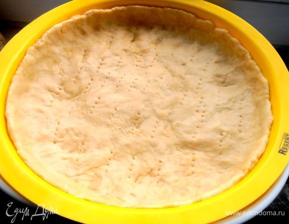 Распределяем тесто по большой форме с бортиками (у меня силиконовая) и накалываем дно вилкой. Выпекаем в разогретой до 180* духовке минут 10-12.