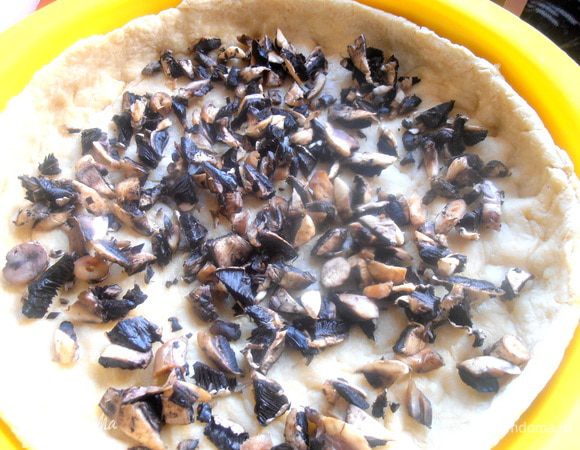 Вынимаем полуготовое тесто и выкладываем на дно грибы...