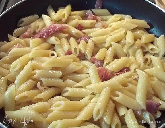 Выкладываем пасту к бекону, обжариваем до золотистого цвета пасты. Снимаем с  огня и выливаем соус, перемешиваем, добавляем немного воды, которой зачерпнули и мускатный орех...