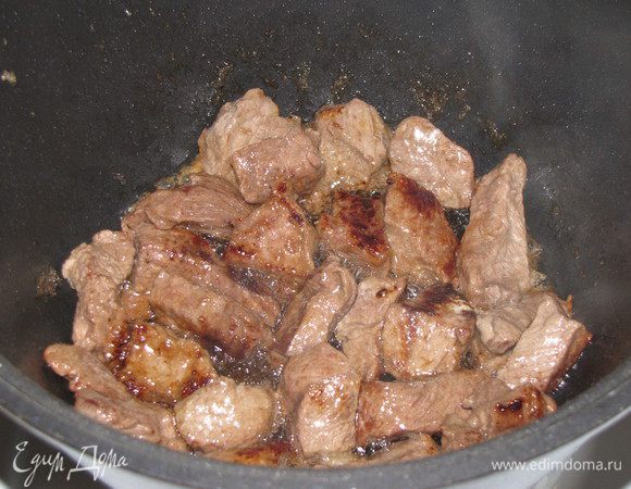 Разогрейте к казане, сотейнике или кастрюле с толстым дном масло, обжарьте в нем мясо на сильном огне до румяной корочки. 