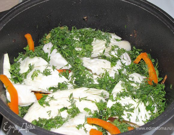 Выложите капусту. Капусту посолите, выложите на нее лавровый лист и часть зелени.