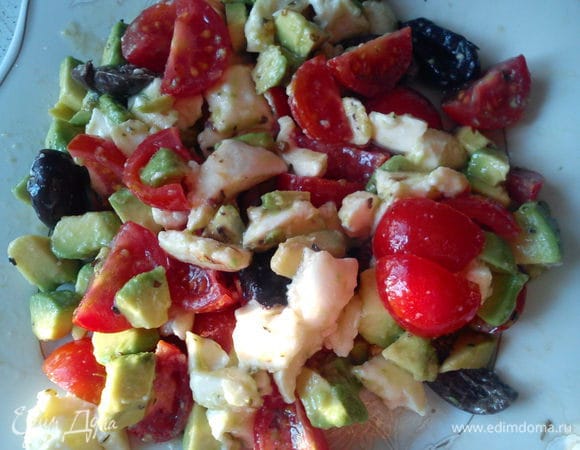 Нарезать авокадо, моцареллу и помидоры небольшими кубиками. Добавить оливки, разрезанные пополам. Полить маслом, соком лимона и приправить специями. Посолить и перемешать.