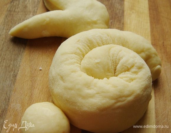 Противень смазать растительным маслом. Собрать зайцев на противне. "Улитка"- туловище, а незакреплённый конец- передние лапки. К "улитке" приставить голову, немного расставив ушки. С противоположной лапкам стороны прикрепить хвостик. Накрыть зайцев полотенцем и оставить для расстойки на 20 минут. Разогреть духовку до 180*С.