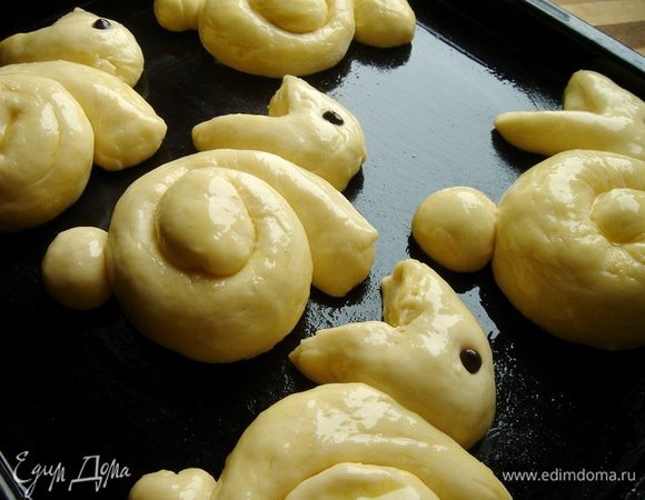 "Подросшим" зайцам установить глаза - шоколадные капли, вдавив их в тесто. Смешать желток, пудру и молоко и смазать этой смесью зайцев. Выпекать около 30 минут. Остывшим зайцам повязать красивые ленточки. Приятного аппетита!