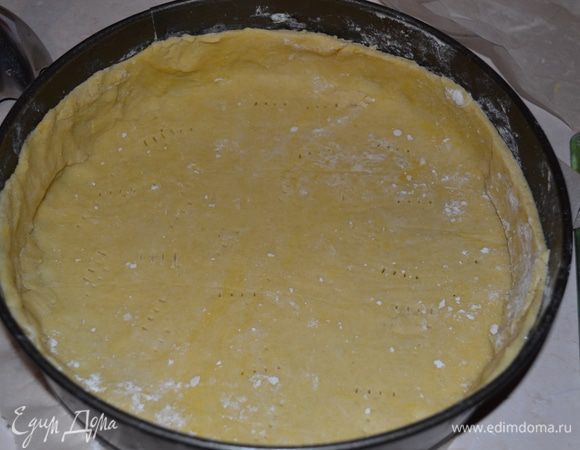 Через час тесто укладываем в низкую круглую форму для выпекания, ровно подрезаем верх и прокалываем вилкой.