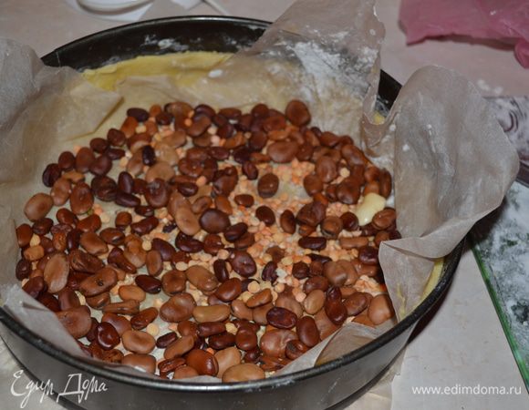 На тесто кладем лист пергаментной бумаги, сверху насыпаем груз (фасоль или горох). Выпекаем основу для тарта в ранее разогретой духовке при темп.175-180 гр. 20-25 минут до слегка золотистого цвета.