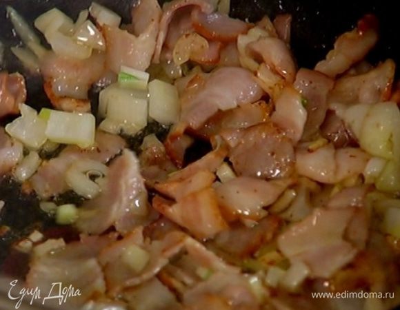 Разогреть в сковороде 2 ст. ложки оливкового масла и, помешивая, обжарить лук и бекон до золотистого цвета.