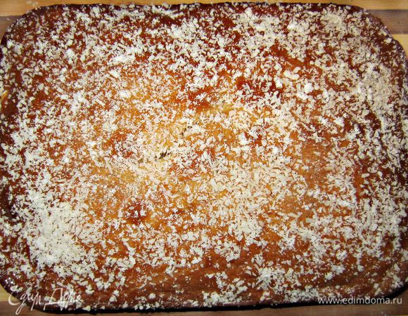 Посыпьте пирог оставшейся кокосовой стружкой и сахарной пудрой (или тёртым шоколадом с корицей).