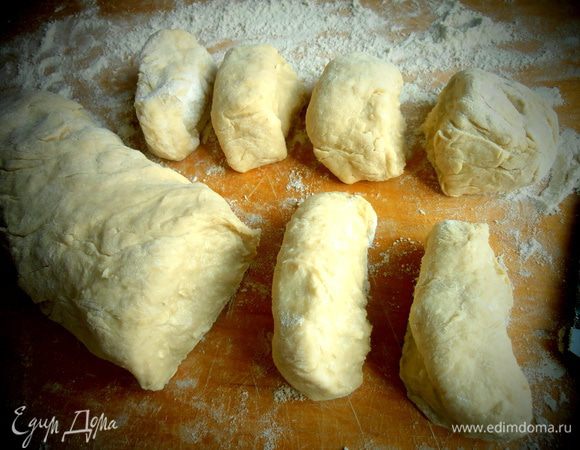 Когда тесто немного постоит и станет пышнее, обваляйте его в муке, нарежьте на равные части и скатайте их в шарики.