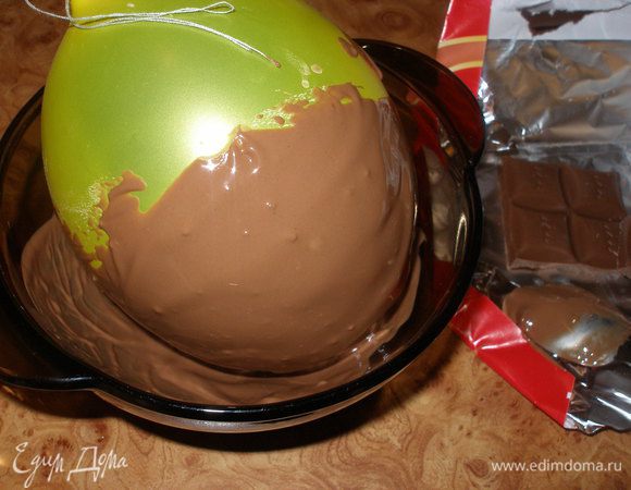 Тем временем,надуть шарик примерно сантиметров 10 в диаметре.Чем больше шарик Вы надуете,тем крупнее получится яйцо,соответственно....чем меньше,то меньше будит яйцо.Крепко завязать.Теперь аккуратно окунуть шарик в теплый шоколад.Делайте это осторожно,иначе шарик может лопнуть и вы и все вокруг окажется в шОкОладе!:)